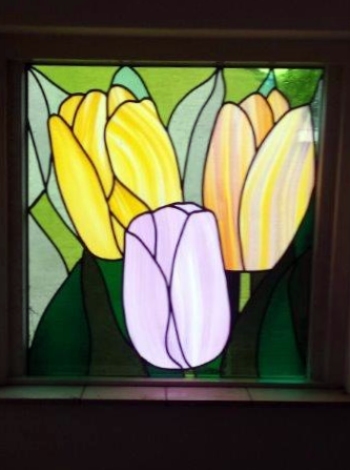 Tulpen van gekleurd figuurglas in glas in lood.